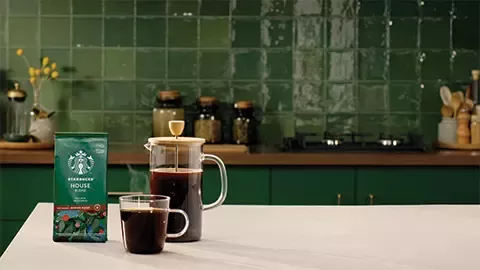 coffee pack, cup of coffee and kettle with coffee on table